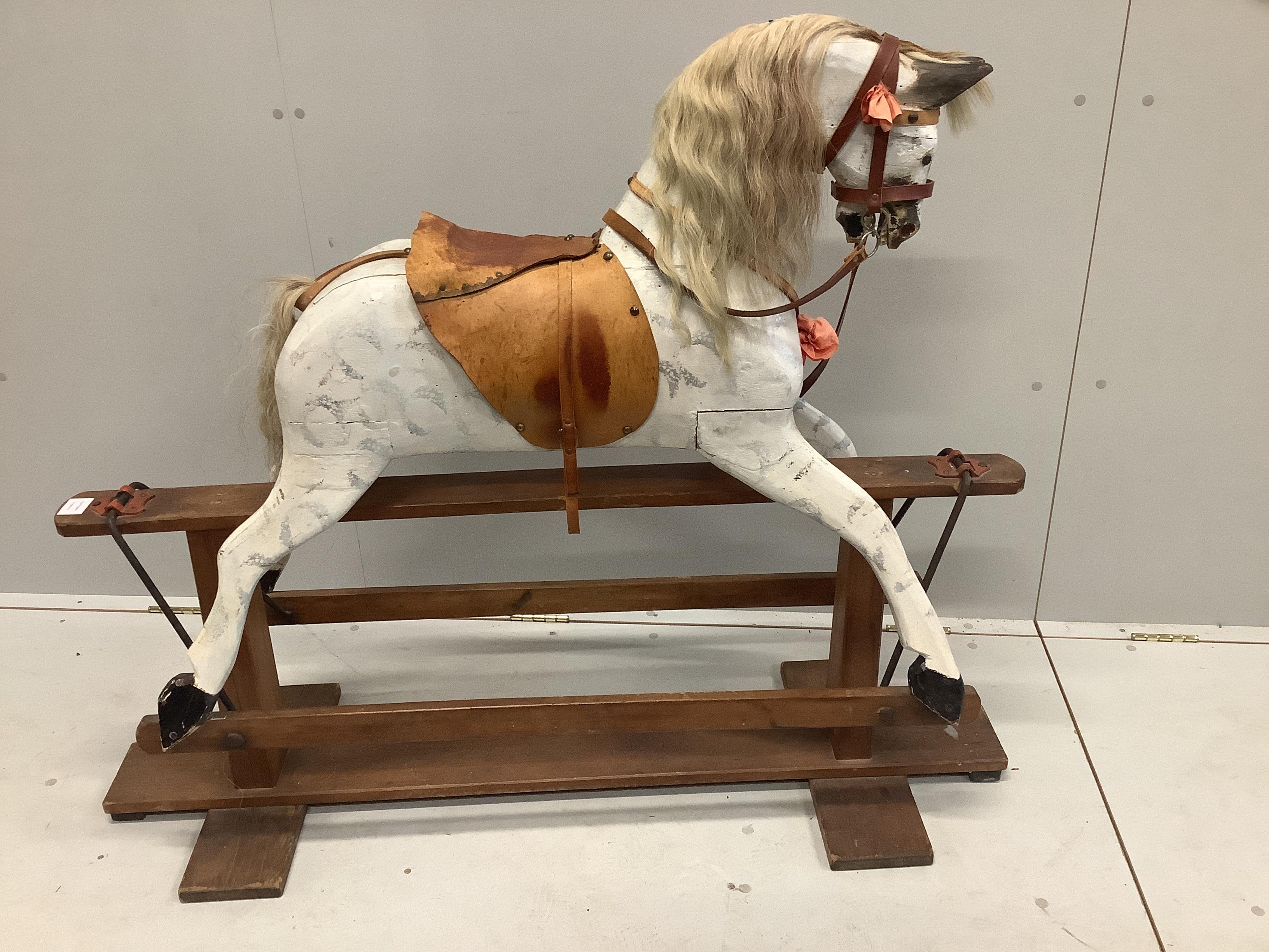 An early 20th century dapple grey rocking horse on pine safety frame, length 130cm, height 106cm